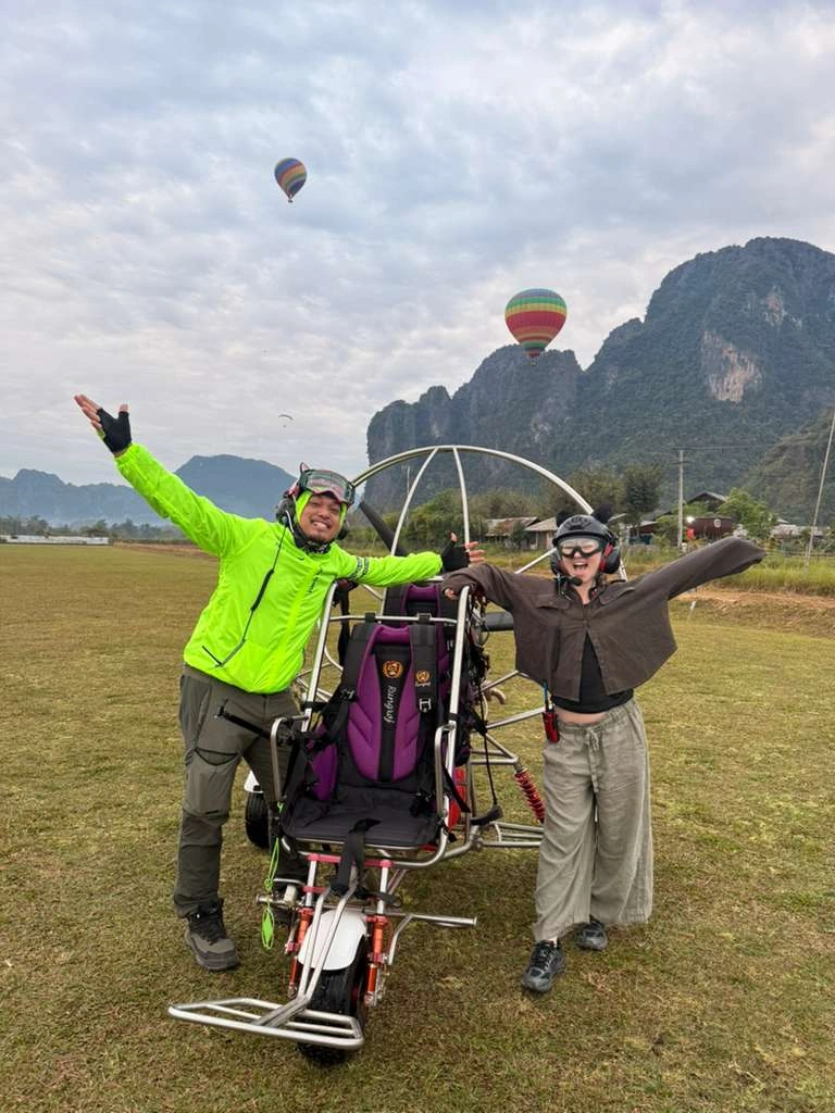 Happy customer after paramotor flight on the ground in Vang Vieng